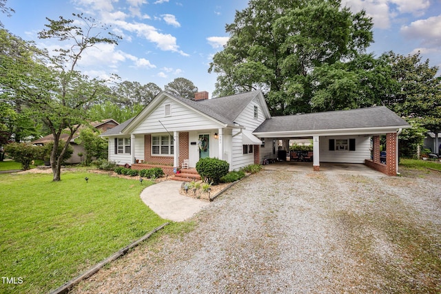 view of front facade featuring gravel driveway, covered porch, a carport, a front yard, and brick siding