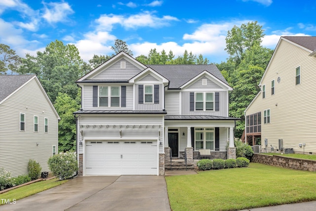 craftsman inspired home with covered porch, driveway, a standing seam roof, and stone siding