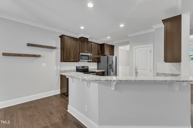 kitchen with appliances with stainless steel finishes, ornamental molding, backsplash, dark brown cabinetry, and dark wood-style flooring