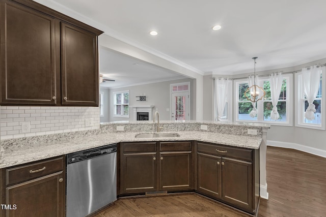 kitchen featuring stainless steel dishwasher, a sink, dark brown cabinets, a peninsula, and backsplash