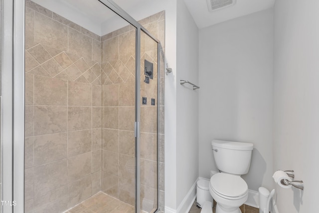 full bathroom featuring toilet, a stall shower, and baseboards
