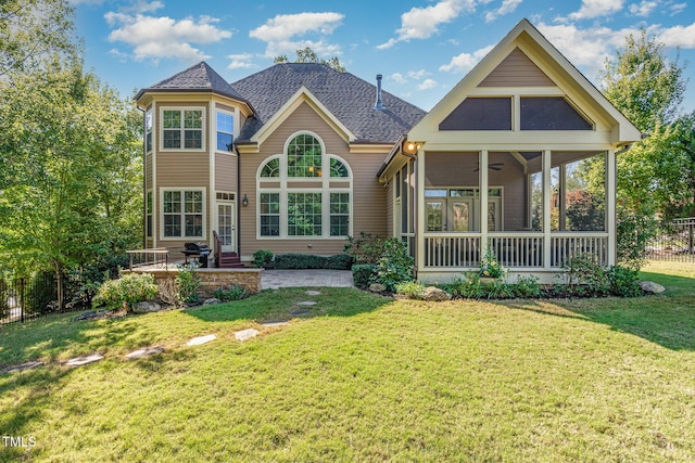 back of property with a sunroom, a patio area, roof with shingles, and a ceiling fan