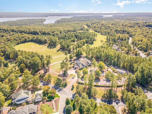 drone / aerial view of a heavily wooded area and a nearby body of water