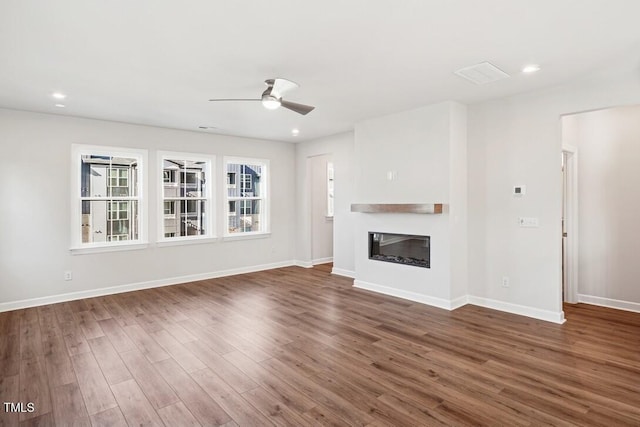 4611 Mint Leaf Ln, Raleigh, NC 27612 - unfurnished living room featuring ceiling fan, wood finished floors, baseboards, a glass covered fireplace, and recessed lighting