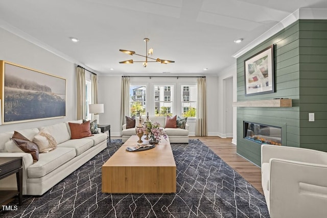 4611 Mint Leaf Ln, Raleigh, NC 27612 - living area with ornamental molding, recessed lighting, a chandelier, a large fireplace, and dark wood-style flooring