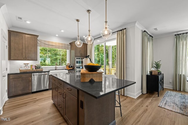 4611 Mint Leaf Ln, Raleigh, NC 27612 - kitchen featuring stainless steel appliances, ornamental molding, dark countertops, decorative backsplash, and light wood-style floors