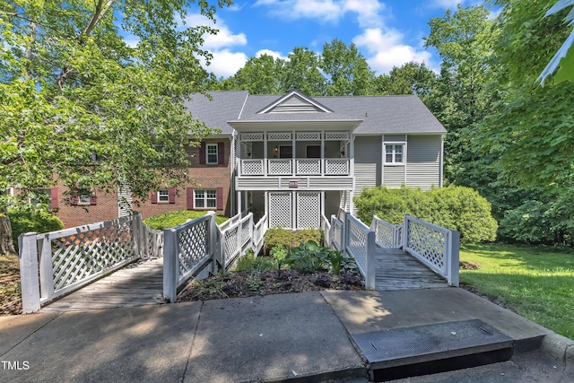 view of front of home featuring a shingled roof and a balcony