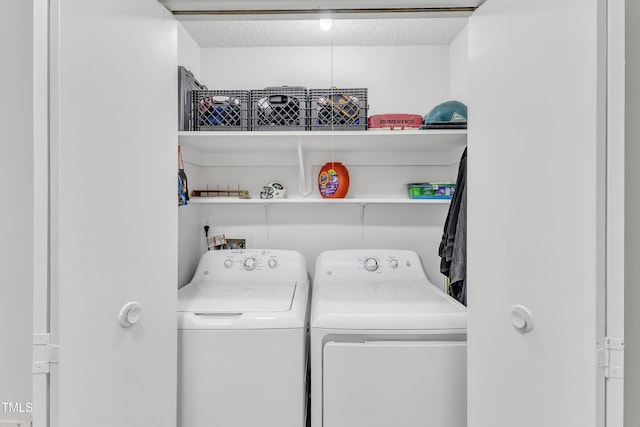 washroom featuring washer and clothes dryer and a textured ceiling