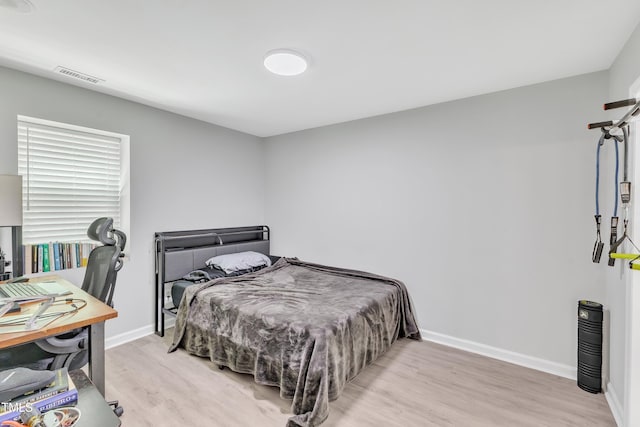 bedroom featuring wood finished floors and baseboards
