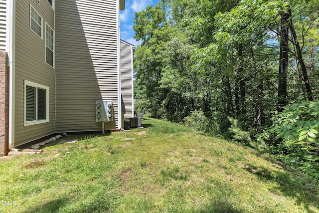 view of green lawn with cooling unit