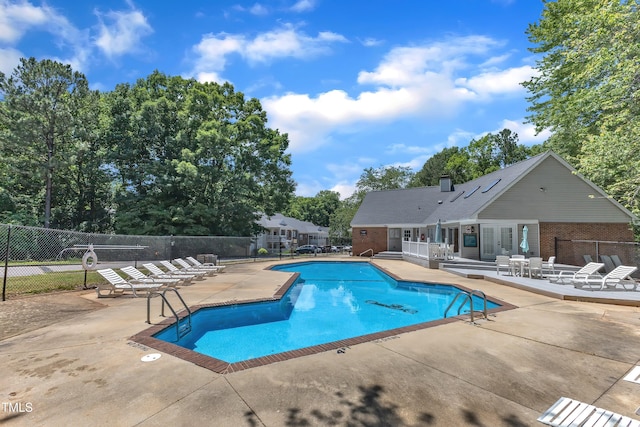 community pool featuring a patio and fence