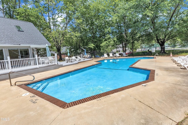 community pool featuring a patio and fence
