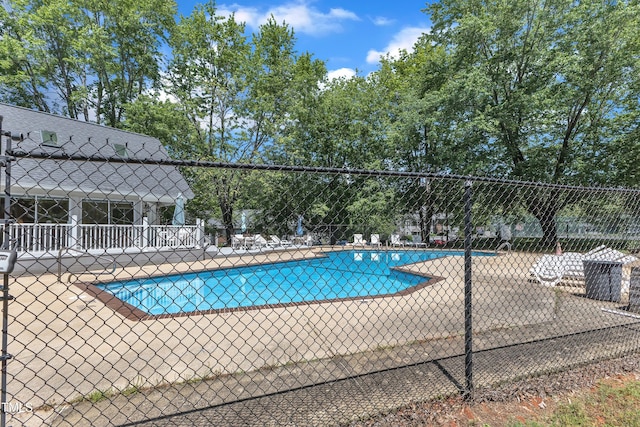 community pool with fence and a patio