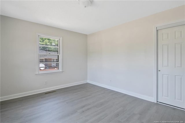 spare room with wood finished floors and baseboards