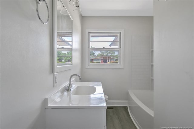 full bath featuring vanity, wood finished floors, and baseboards
