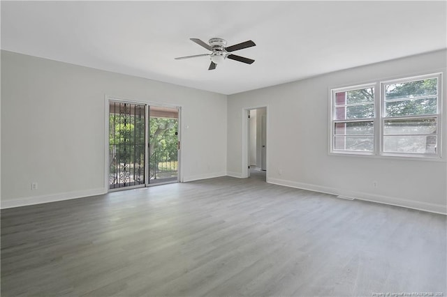 spare room with healthy amount of natural light, a ceiling fan, baseboards, and wood finished floors