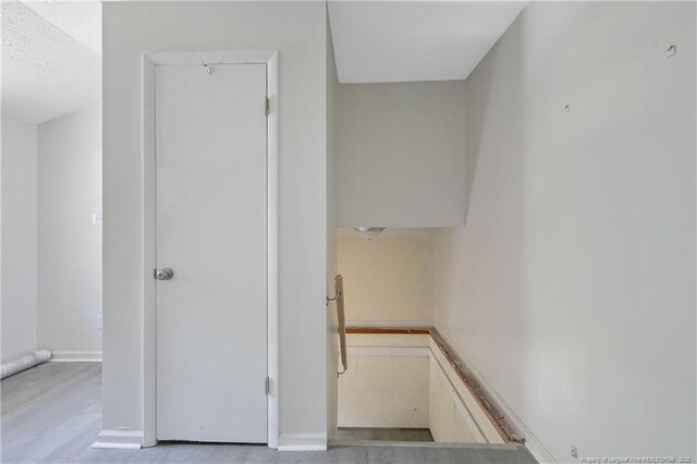 staircase featuring baseboards and wood finished floors