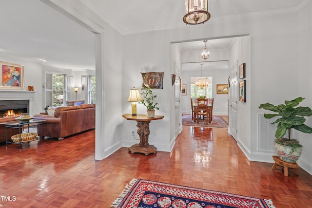 entryway with a chandelier, healthy amount of natural light, baseboards, and crown molding
