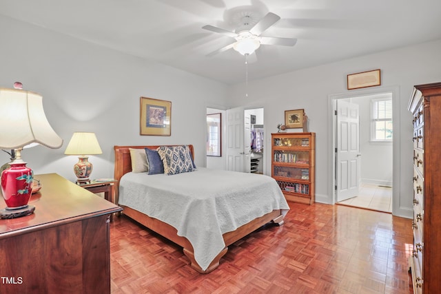 bedroom with baseboards, a ceiling fan, and a spacious closet