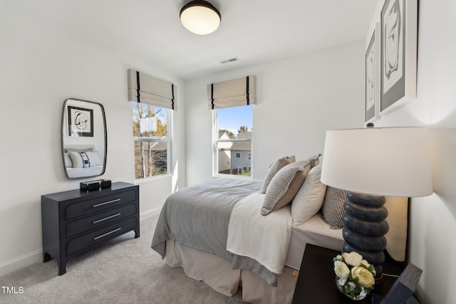 bedroom with light colored carpet and baseboards