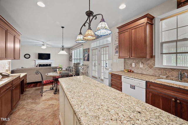 111 Gingergate Dr, Cary, NC 27519 - kitchen featuring white dishwasher, ceiling fan, a fireplace, decorative backsplash, and open floor plan
