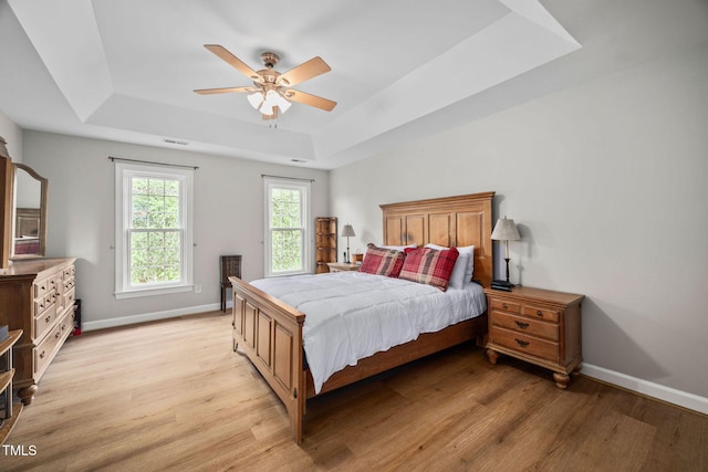 111 Gingergate Dr, Cary, NC 27519 - bedroom with a tray ceiling, light wood-style flooring, baseboards, and ceiling fan