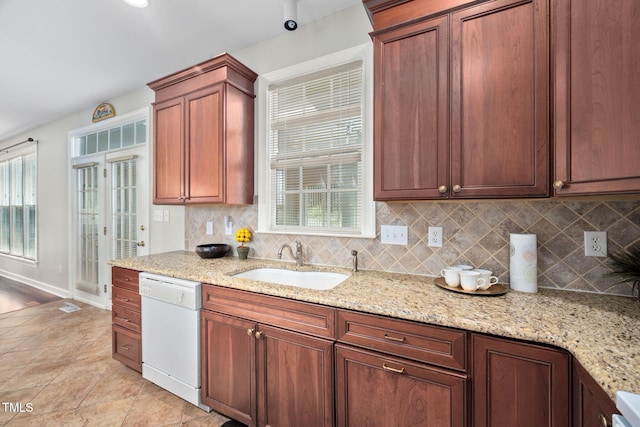 111 Gingergate Dr, Cary, NC 27519 - kitchen with white dishwasher, decorative backsplash, light stone counters, and light tile patterned floors
