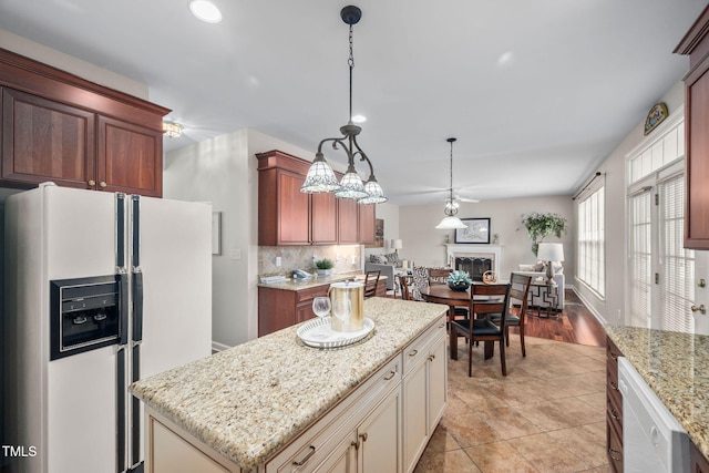 111 Gingergate Dr, Cary, NC 27519 - kitchen featuring white appliances, open floor plan, a fireplace, a kitchen island, and hanging light fixtures