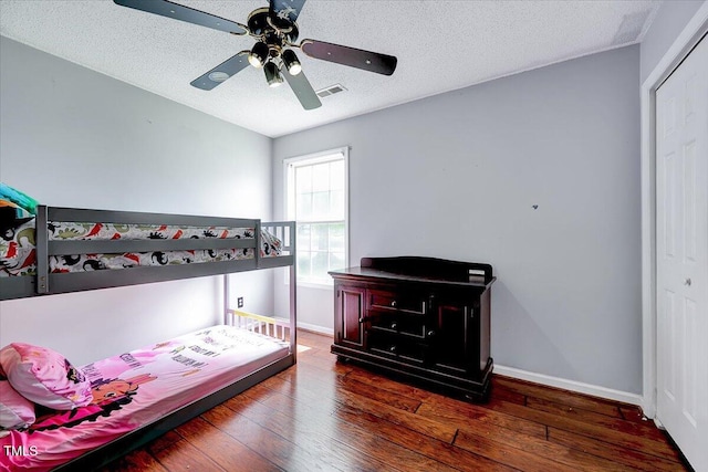 bedroom featuring hardwood / wood-style flooring, baseboards, a textured ceiling, ceiling fan, and a closet