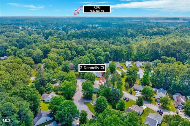 aerial perspective of suburban area featuring a heavily wooded area