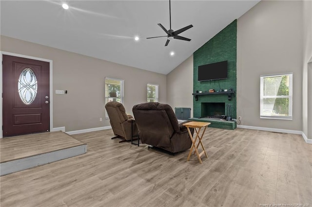300 Fox Ridge Rd, Warsaw, NC 28398 - living room featuring high vaulted ceiling, ceiling fan, wood finished floors, a brick fireplace, and baseboards