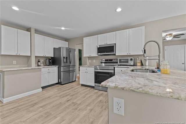 300 Fox Ridge Rd, Warsaw, NC 28398 - kitchen with appliances with stainless steel finishes, a sink, white cabinetry, light stone countertops, and light wood-style floors