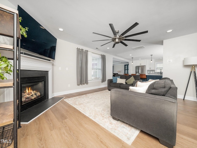 4502 Joe Cotton Dr, Knightdale, NC 27545 - living area with a ceiling fan, wood finished floors, a glass covered fireplace, baseboards, and recessed lighting