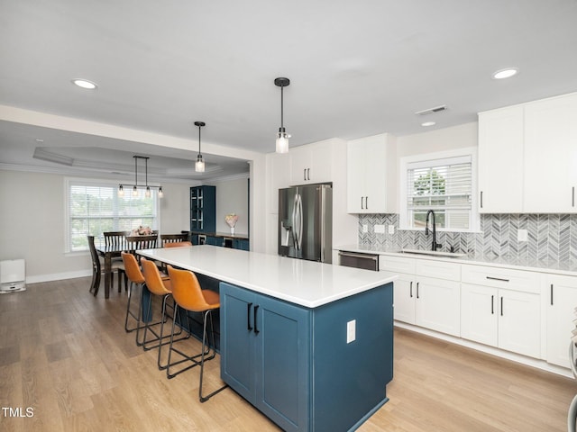 4502 Joe Cotton Dr, Knightdale, NC 27545 - kitchen with a sink, stainless steel appliances, a kitchen island, tasteful backsplash, and white cabinets