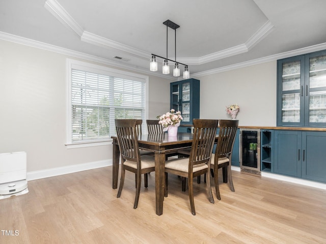 4502 Joe Cotton Dr, Knightdale, NC 27545 - dining space featuring wine cooler, light wood-style floors, ornamental molding, a raised ceiling, and baseboards