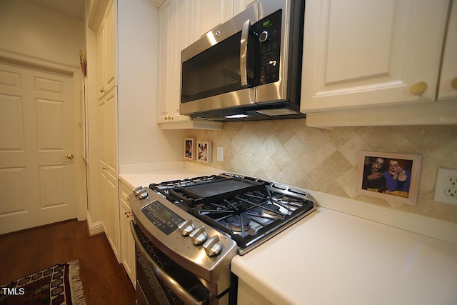 2901 Market Bridge Ln Unit 203, Raleigh, NC 27608 - kitchen featuring appliances with stainless steel finishes, backsplash, light countertops, dark wood-style flooring, and white cabinets