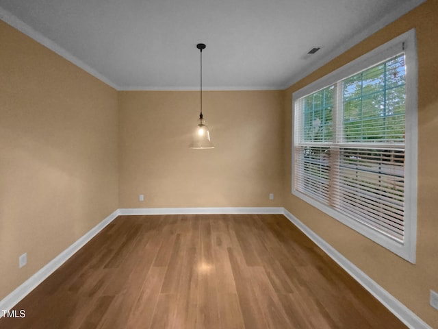 unfurnished dining area featuring baseboards, wood finished floors, and ornamental molding