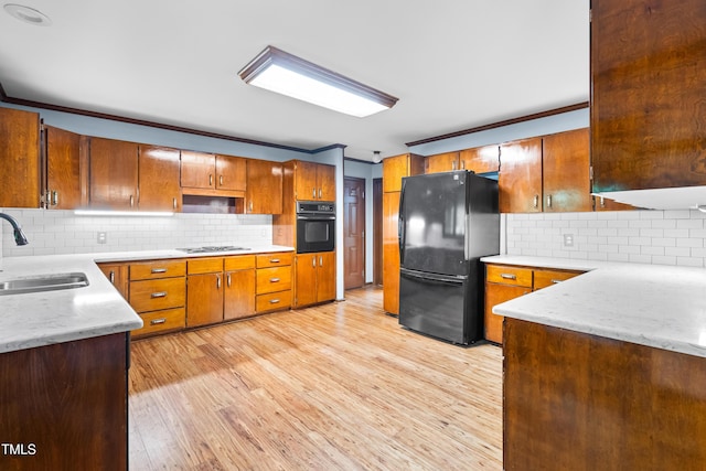 1608 New Hill Olive Chapel Rd, Apex, NC 27502 - kitchen featuring black appliances, a sink, crown molding, decorative backsplash, and light wood-style floors