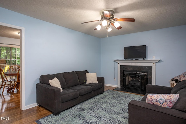129 Clark Ct, Youngsville, NC 27596 - living area featuring a ceiling fan, wood finished floors, a fireplace, baseboards, and a textured ceiling