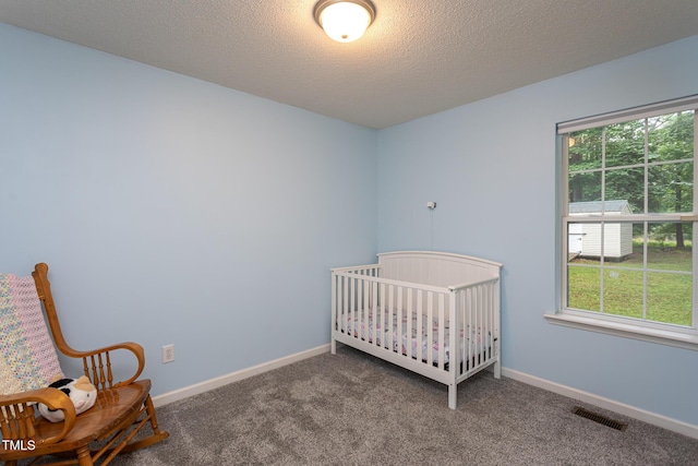 129 Clark Ct, Youngsville, NC 27596 - carpeted bedroom featuring baseboards, a nursery area, and a textured ceiling