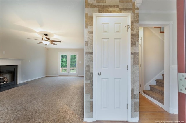 109 Sand Dollar Ct, Raeford, NC 28376 - unfurnished living room with ceiling fan, stairs, a fireplace with flush hearth, ornamental molding, and carpet