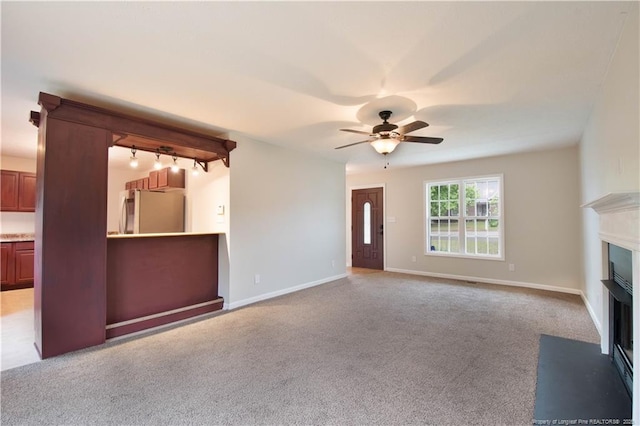 109 Sand Dollar Ct, Raeford, NC 28376 - unfurnished living room with a fireplace with flush hearth, ceiling fan, light carpet, baseboards, and rail lighting
