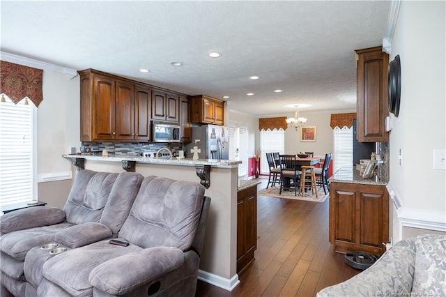 430 Rose Rd, Newton Grove, NC 28366 - kitchen featuring appliances with stainless steel finishes, a chandelier, a peninsula, dark wood-style flooring, and decorative backsplash