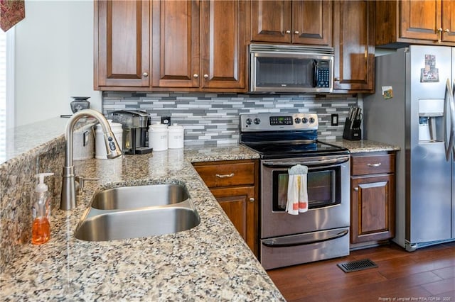 430 Rose Rd, Newton Grove, NC 28366 - kitchen featuring appliances with stainless steel finishes, a sink, dark wood finished floors, tasteful backsplash, and light stone countertops