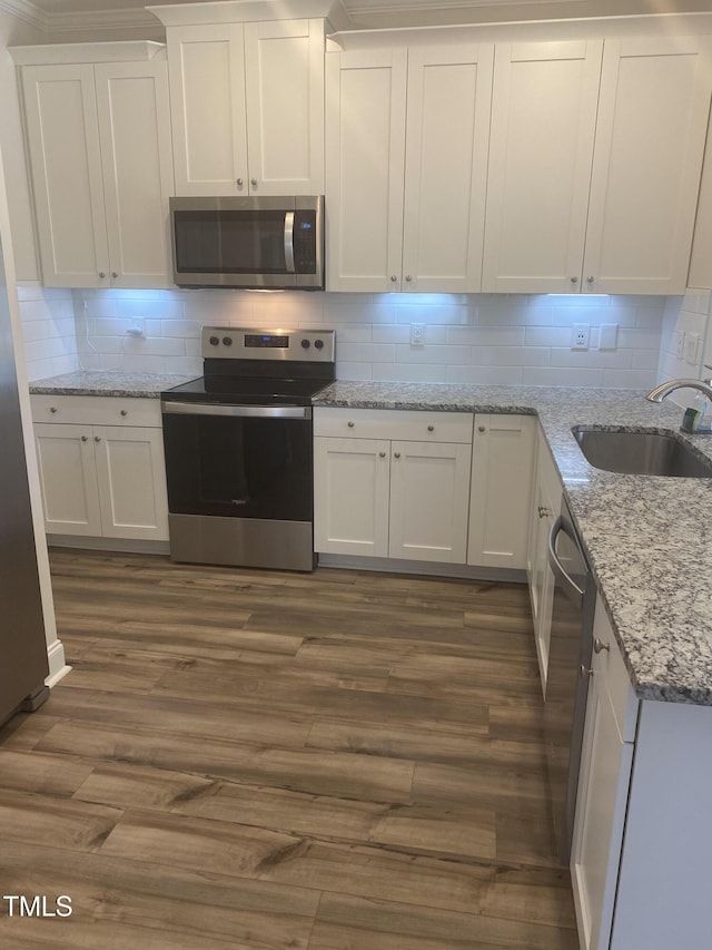 400 Access Dr, Youngsville, NC 27596 - kitchen with appliances with stainless steel finishes, dark wood-type flooring, white cabinetry, and backsplash