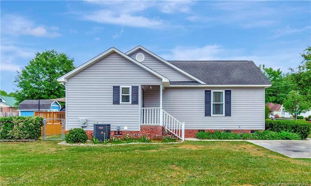 1501 E 6th St, Lumberton, NC 28358 - view of front facade featuring a front yard, crawl space, roof with shingles, and central air condition unit
