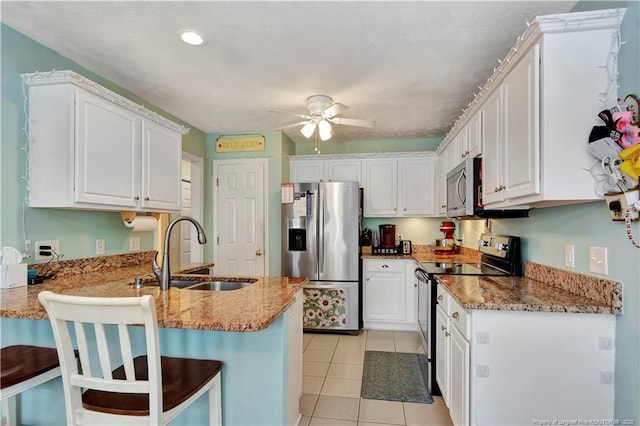 1501 E 6th St, Lumberton, NC 28358 - kitchen featuring appliances with stainless steel finishes, a sink, a peninsula, a ceiling fan, and white cabinets