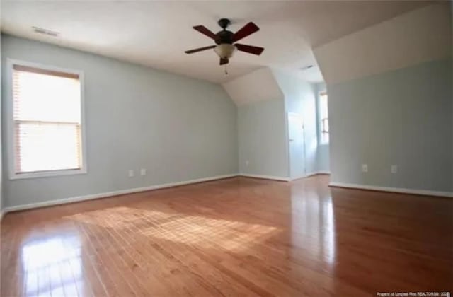 bonus room with wood finished floors, baseboards, ceiling fan, and vaulted ceiling