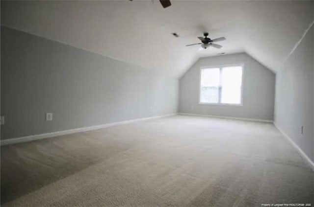 bonus room with lofted ceiling, carpet floors, a ceiling fan, and baseboards