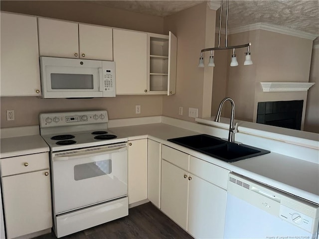 kitchen with white appliances, a sink, light countertops, dark wood-type flooring, and ornamental molding